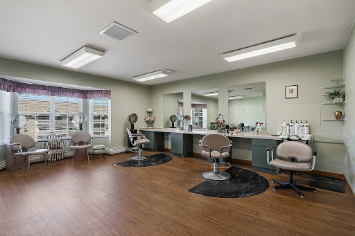 A modern salon interior featuring stylist chairs, mirrors, and a warm wooden floor.