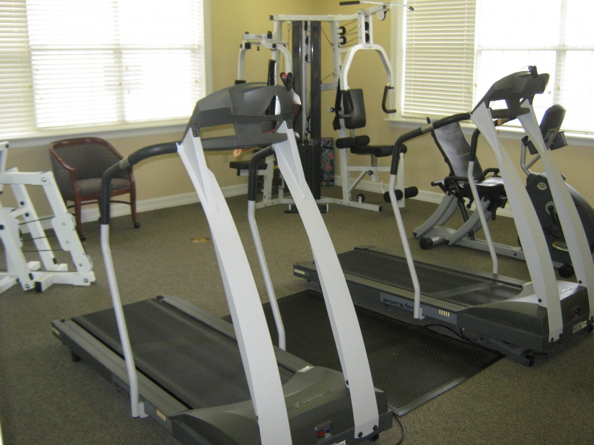 A gym room featuring treadmills and other fitness equipment.