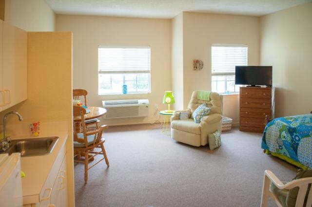 A cozy living room with a recliner, television, and dining area.