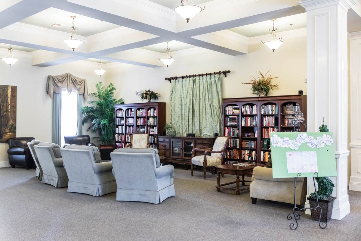 A cozy library room with bookshelves and a comfortable seating area.