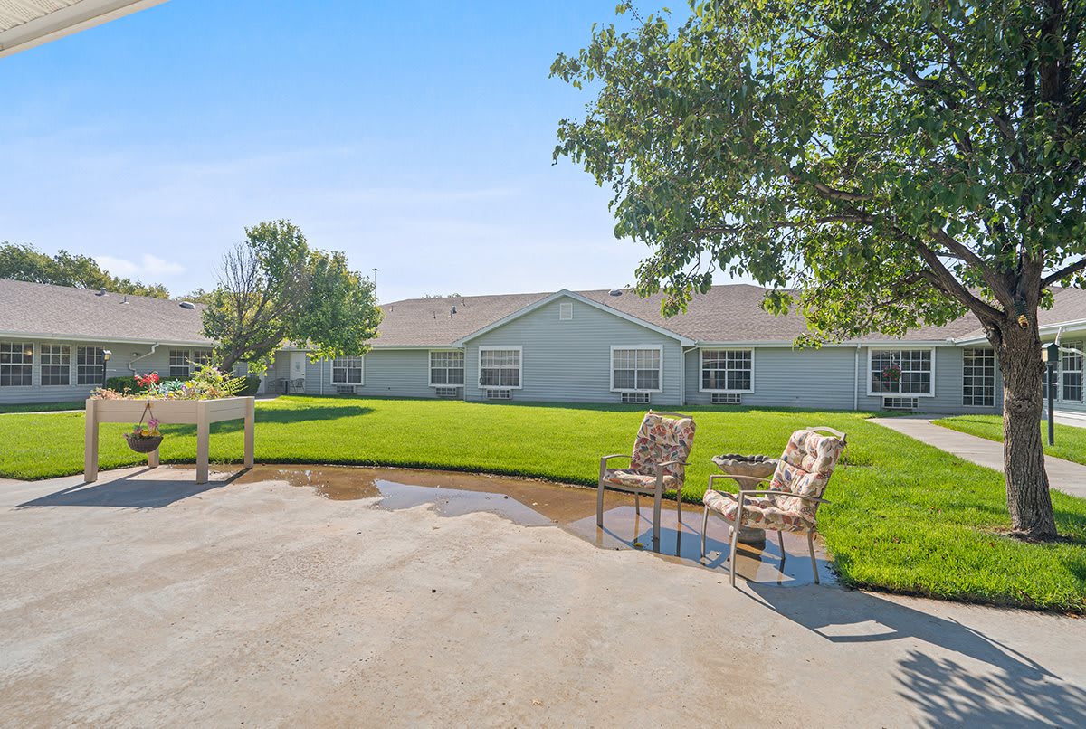 A spacious backyard with a neatly maintained lawn and a seating area on the patio.