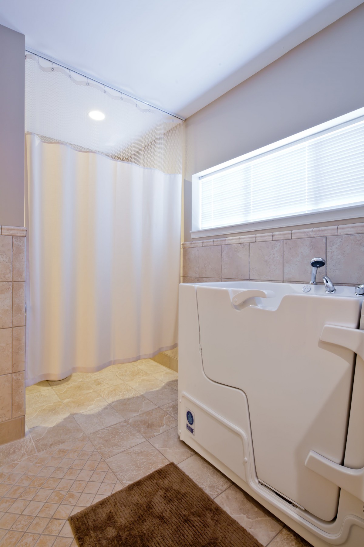 An accessible bathroom featuring a walk-in tub and a shower with tiled walls.