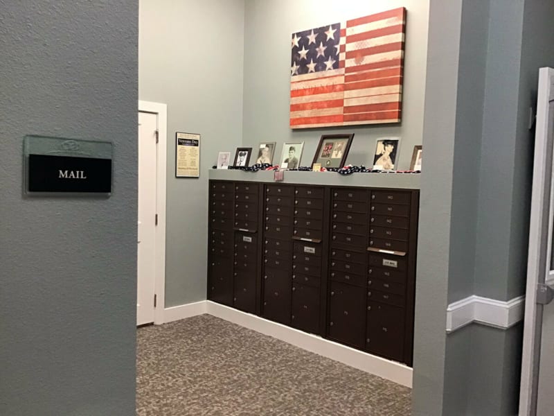 An office space with an American flag on the wall, showcasing furniture and framed photographs.