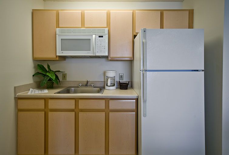 A small kitchen with a microwave, refrigerator, and sink.