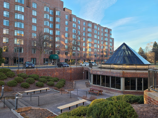 A view of a modern building complex with surrounding green spaces and seating areas.