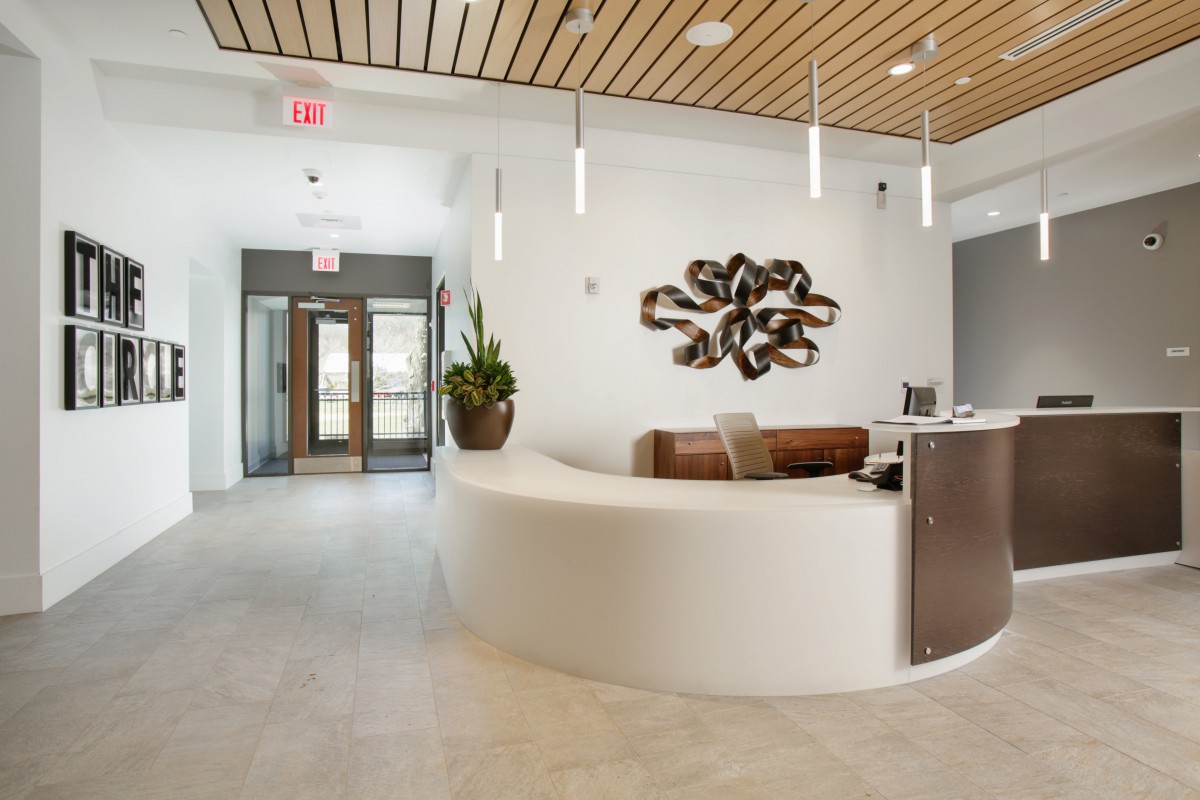 A modern reception area with a curved desk, stylish artwork, and contemporary lighting.