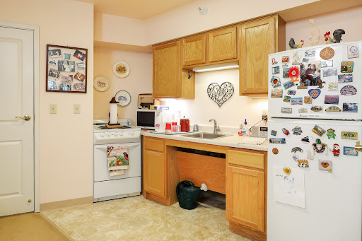 A cozy kitchen featuring wooden cabinets, essential appliances, and a warm atmosphere.