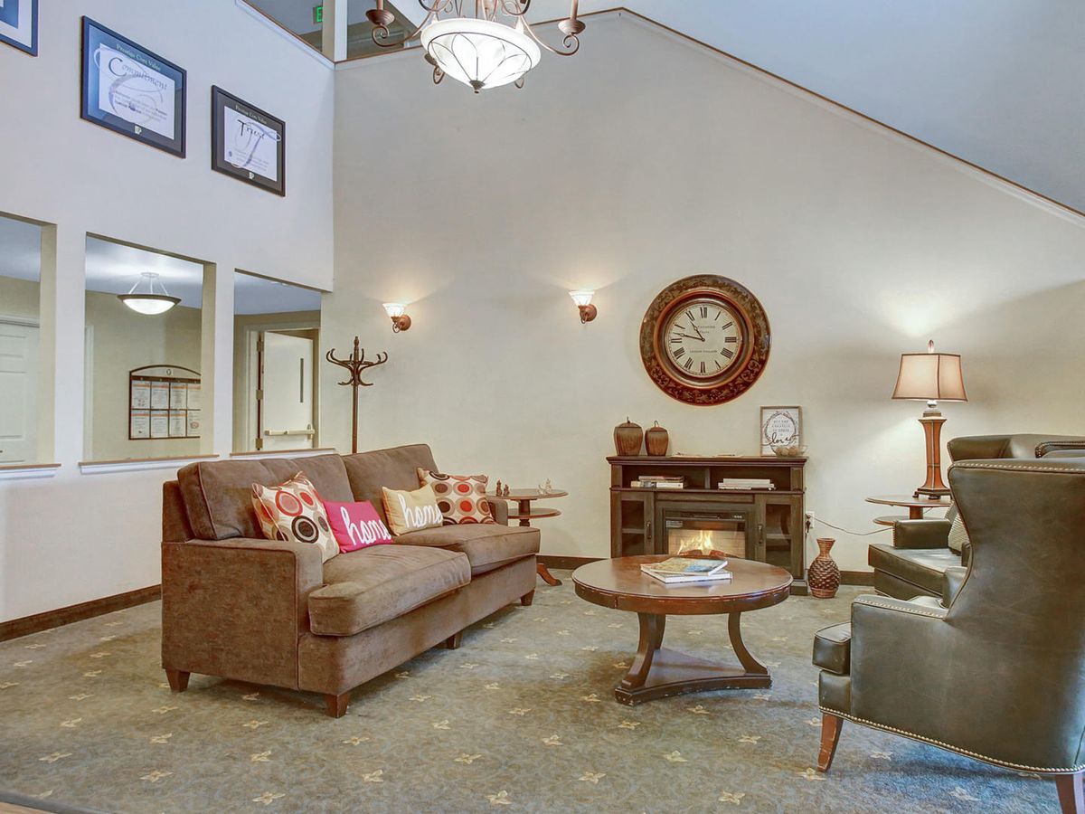 A cozy living room with a comfortable sofa, coffee table, and elegant chandelier.