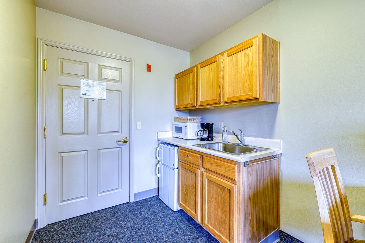 Compact kitchenette area with wooden cabinets and essential appliances.