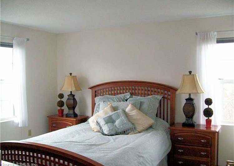 A cozy bedroom with a neatly made bed and two bedside lamps.