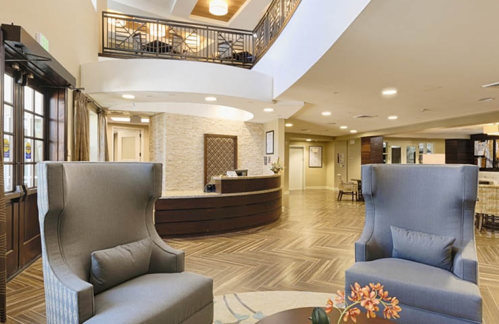 A modern hotel lobby with comfortable seating and a central reception desk.