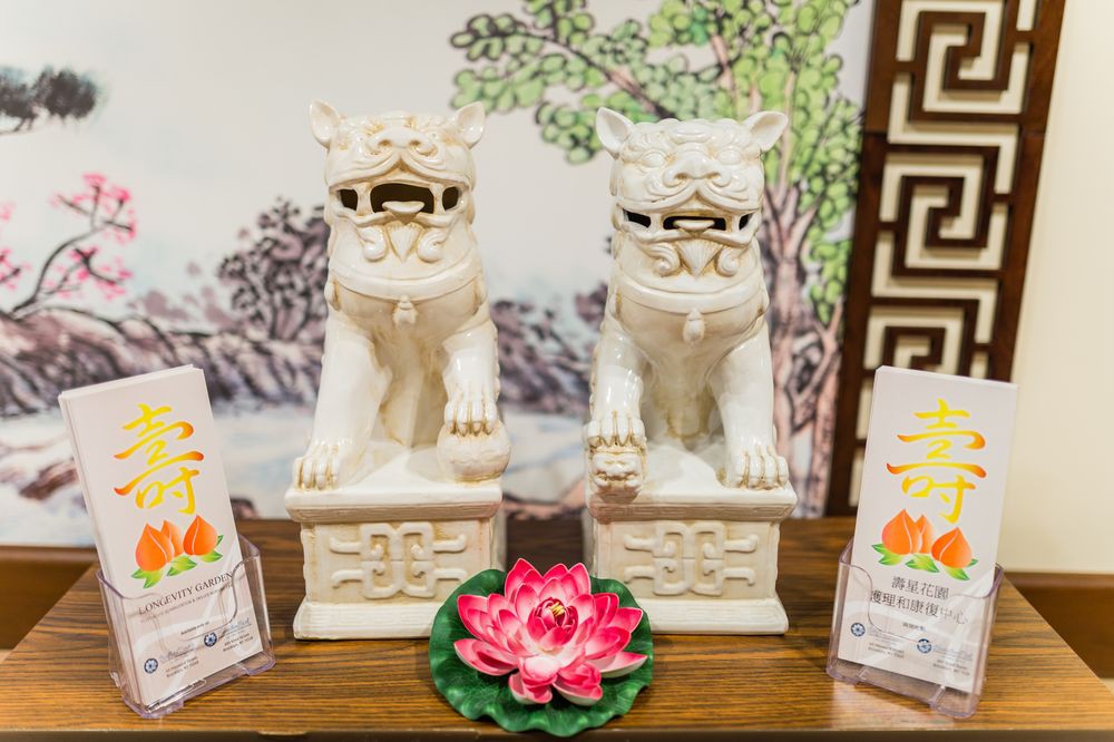 A decorative display featuring two white guardian lion statues and a lotus flower.