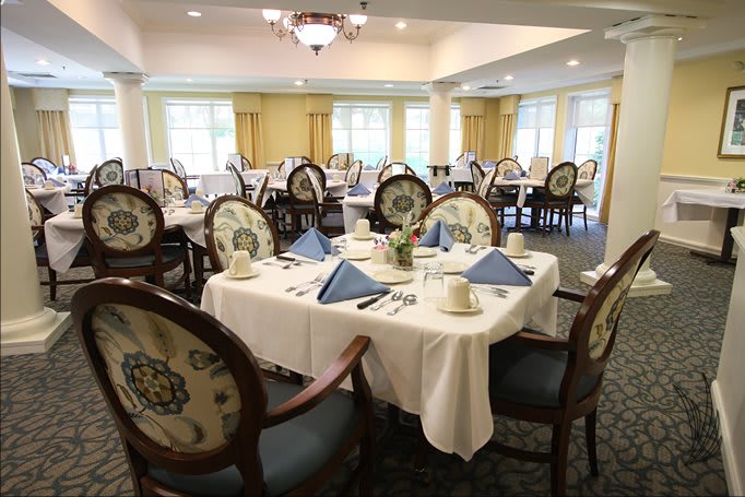 An elegantly set dining room with neatly arranged tables and chairs.