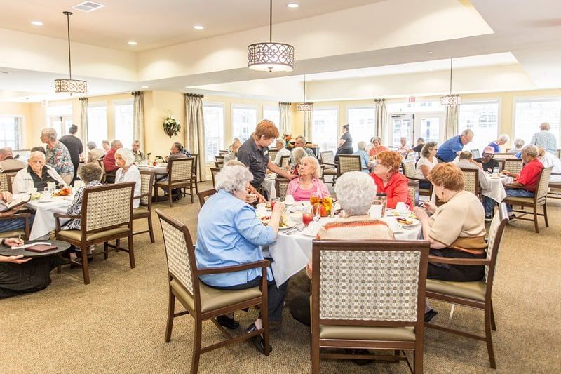 A group of seniors enjoying a meal together in a dining area.