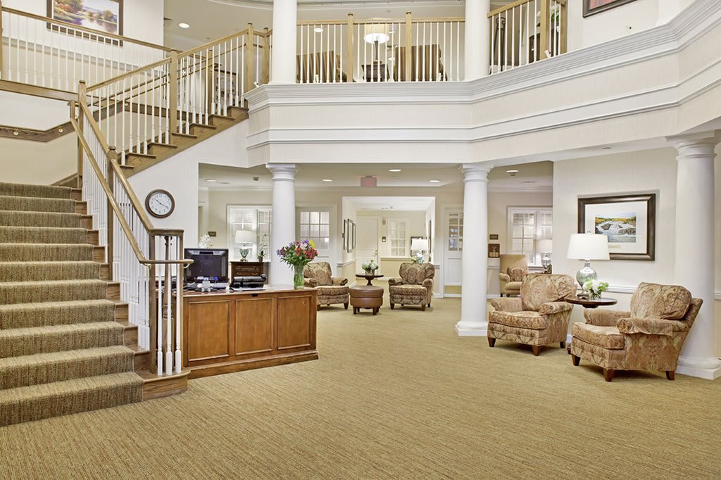 A spacious lobby area with comfortable seating and a central staircase, creating an inviting atmosphere.