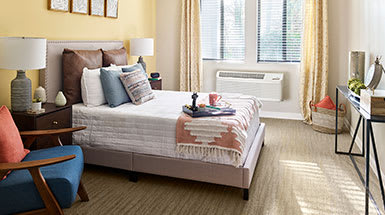 A cozy bedroom with a neatly made bed and stylish decor.