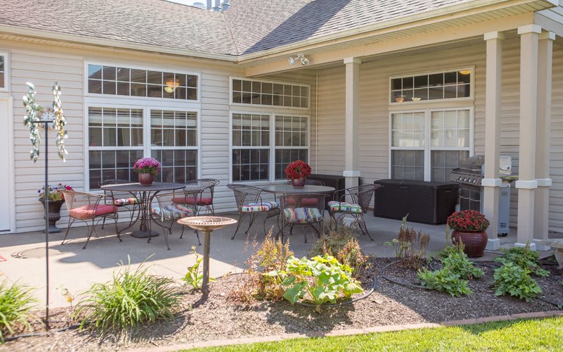 A cozy patio area with outdoor seating, surrounded by a well-maintained garden.