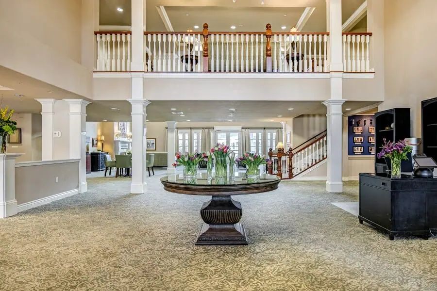 Spacious, elegantly decorated lobby with a central table and staircase.