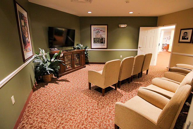 A cozy home theater room with comfortable seating and a large television.