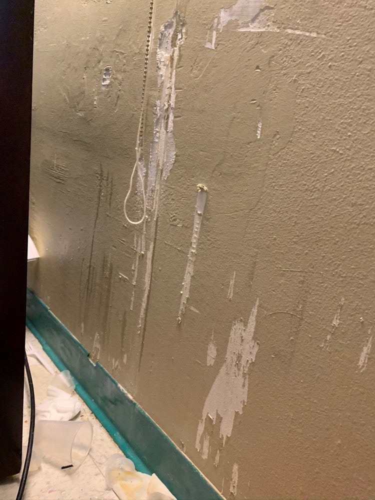 A partially repaired wall with patches and paint preparation.