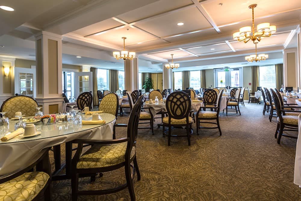 An elegantly designed dining room with neatly arranged tables and chairs, ready for guests.
