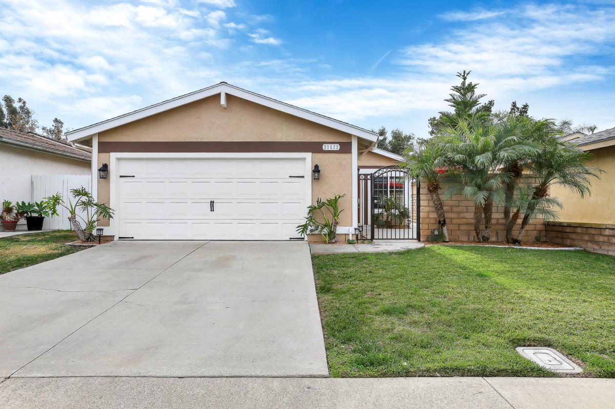 A suburban house with a two-car garage and a well-maintained lawn.