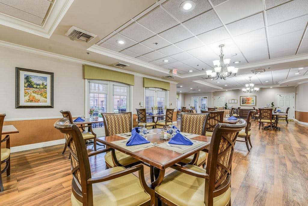 A well-lit dining area with neatly arranged tables and chairs.