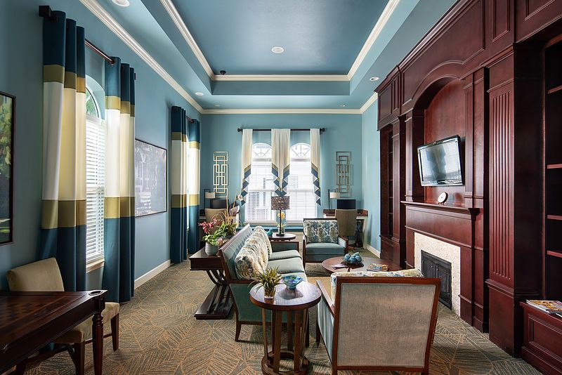 A luxurious living room with elegant decor, featuring blue walls and classic furnishings.