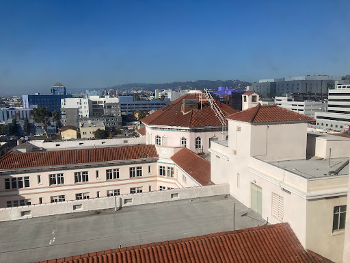 A scenic view of rooftops against a clear blue sky in an urban setting.