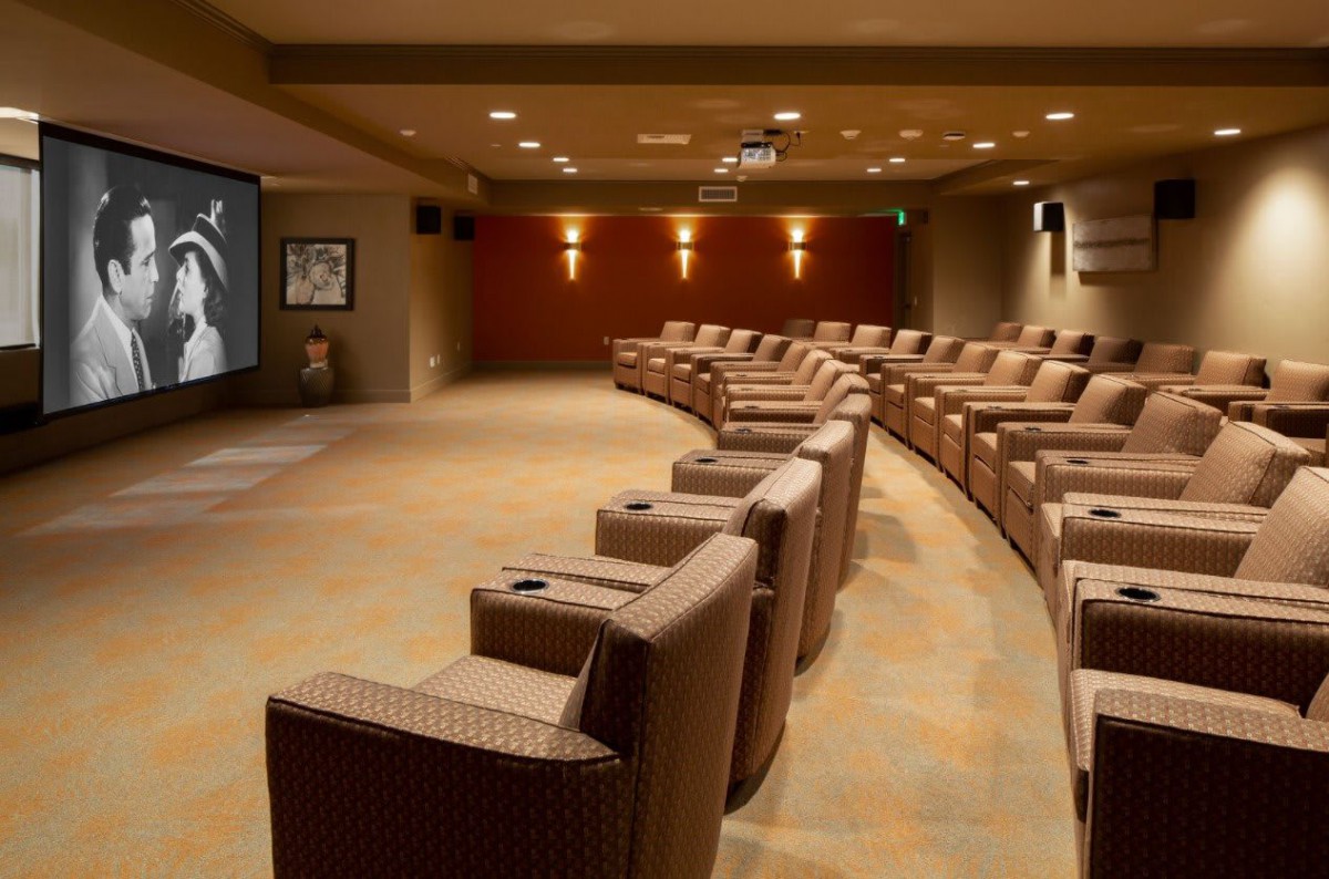 A luxurious home theater with curved seating arrangement and ambient lighting.