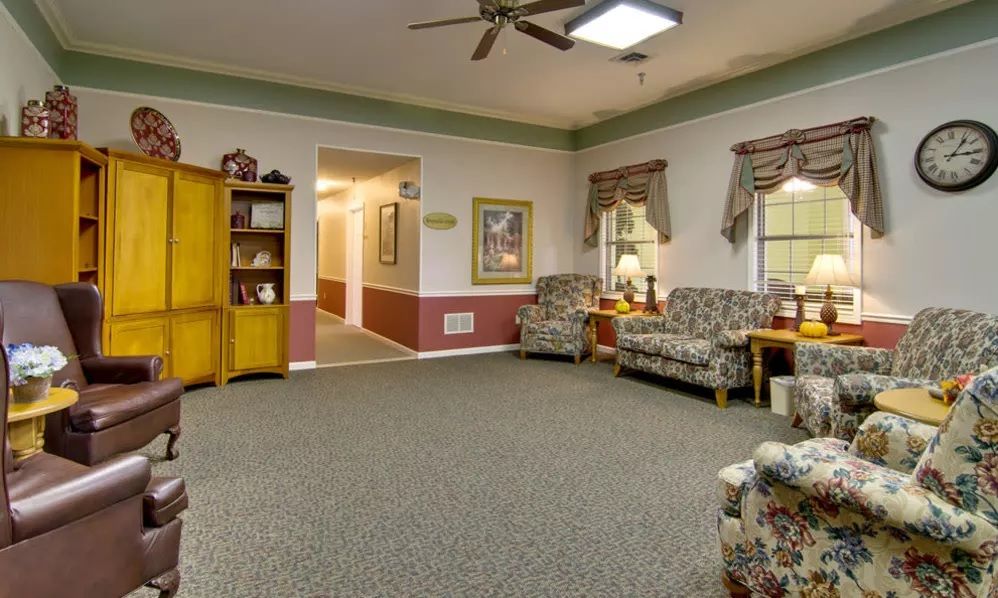 A cozy living room with floral-patterned sofas and warm lighting.