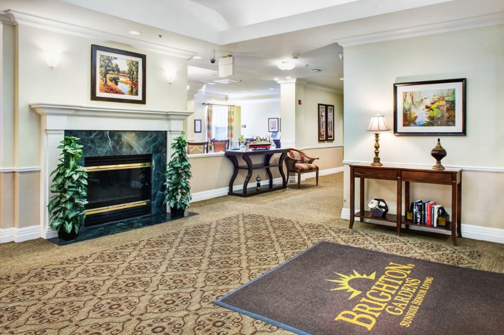 A welcoming lobby area featuring a fireplace, elegant furniture, and artwork on the walls.