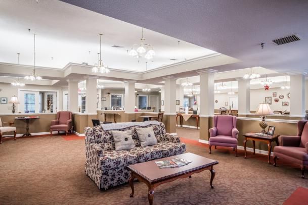 A spacious and elegantly designed lobby with comfortable seating, including a sofa and upholstered chairs, under stylish lighting.