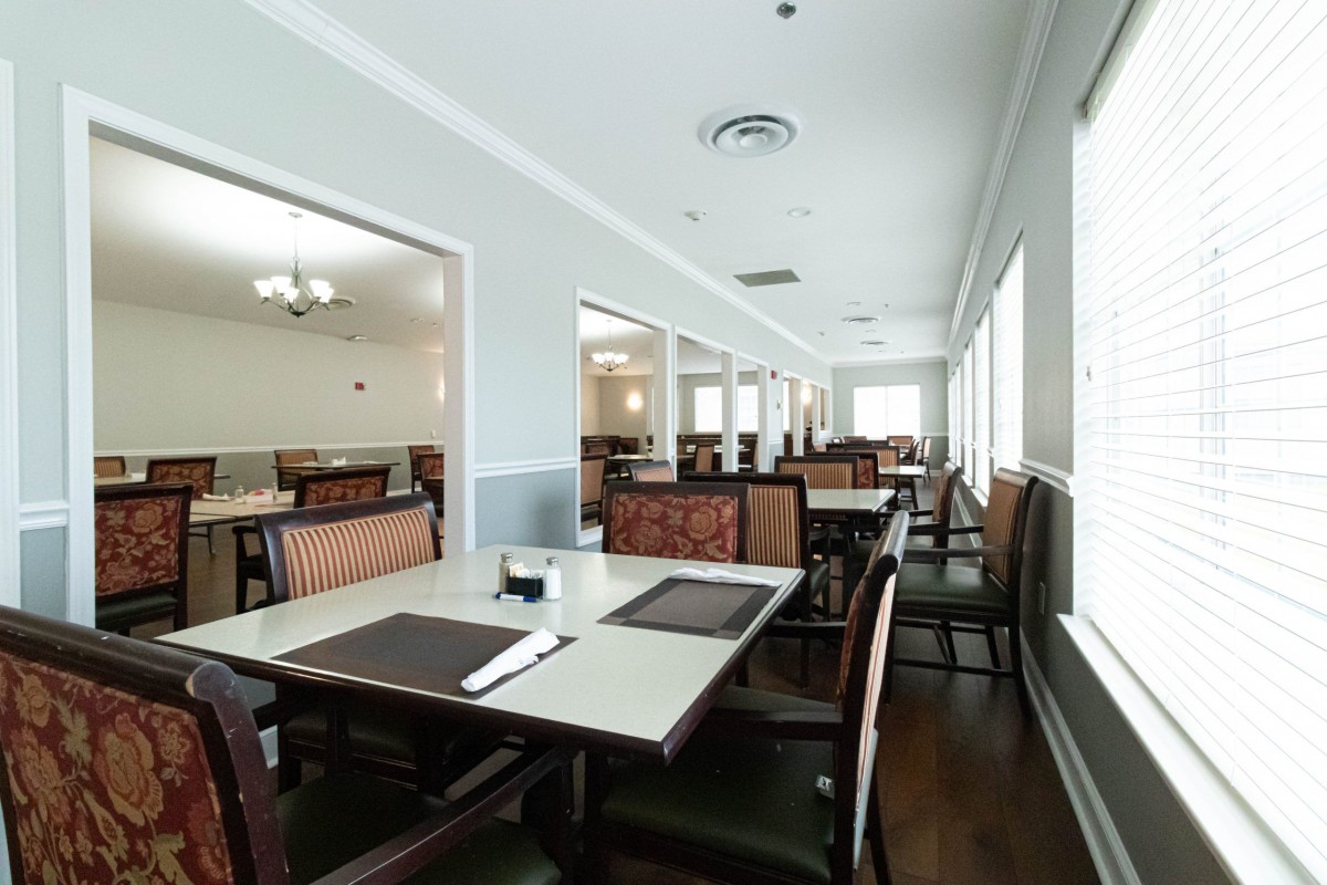 An empty restaurant dining area with neatly arranged tables and chairs.