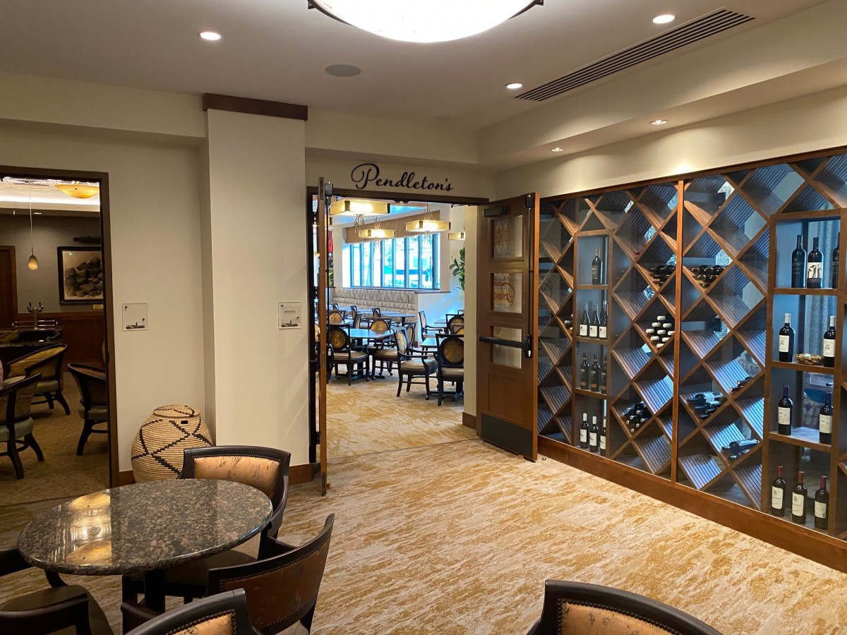 A cozy dining area with a prominent wine rack and elegant furnishings.