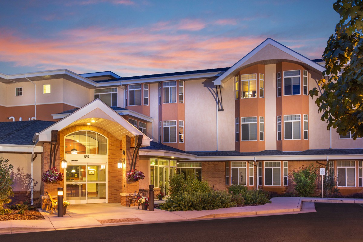 A modern hotel building with a well-lit entrance during the evening.