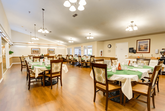 Elegantly set dining area with tables and chairs in a warmly lit restaurant.