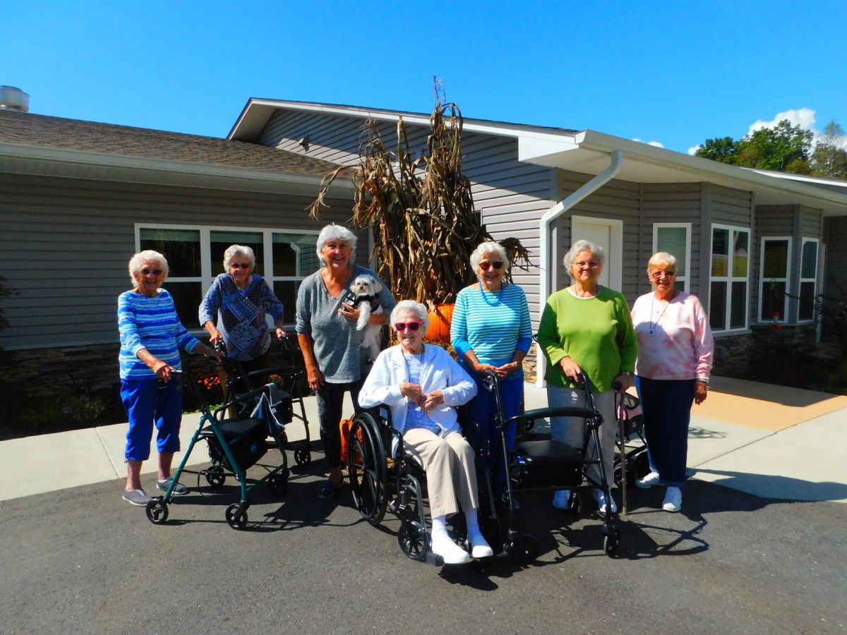 A group of seniors enjoying a sunny day outside a building.