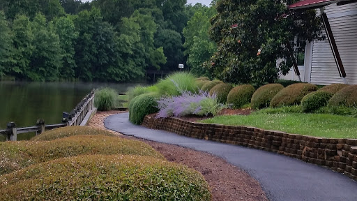 A serene pathway winding through a beautifully landscaped park by the water.