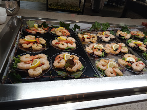 A beautifully arranged display of shrimp appetizers, garnished with lemon slices and served on decorative plates.