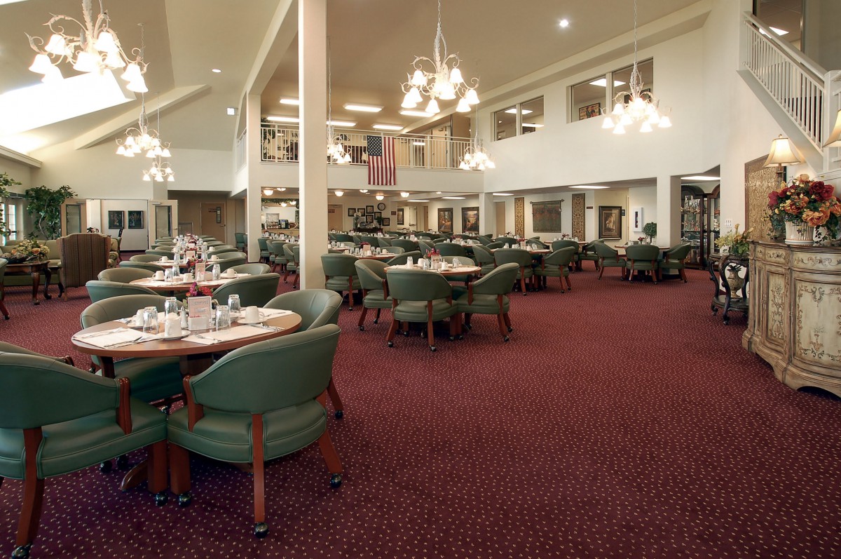 Spacious restaurant interior with elegant chandeliers and neatly arranged tables.