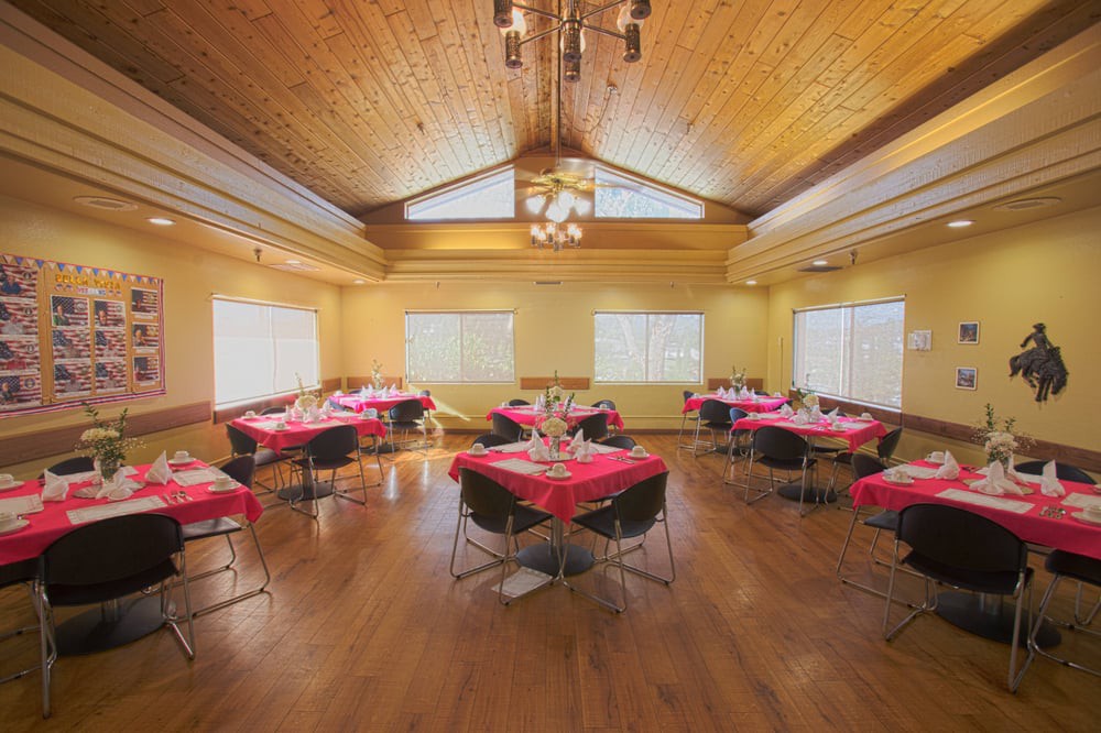 A cozy dining area with red tablecloths and a wooden ceiling.