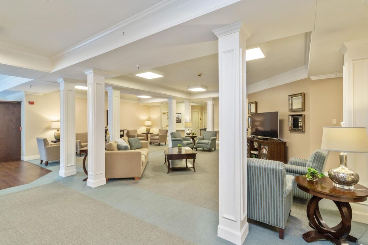 A spacious and cozy lounge area with comfortable seating and classic columns.