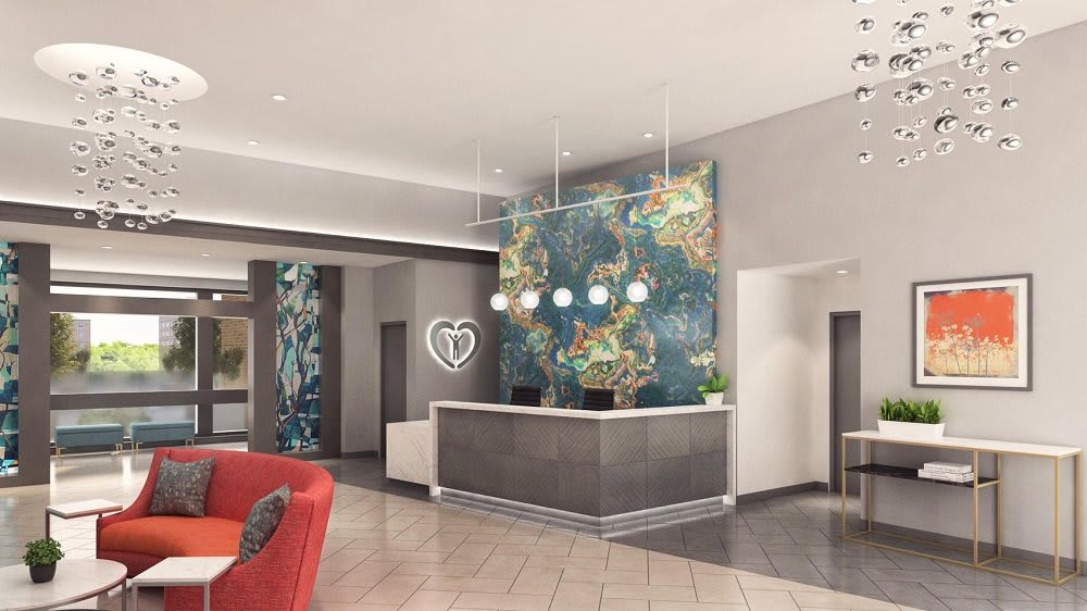 A stylish hotel lobby featuring a modern reception desk and vibrant wall art.