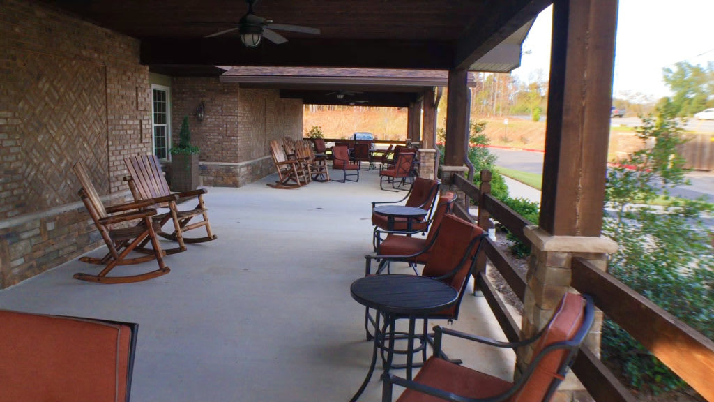 A spacious porch with various seating options and outdoor furniture.