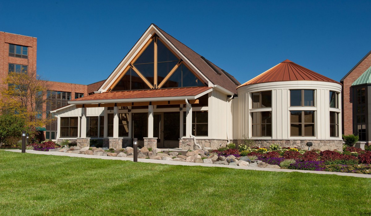 A modern residential house with a unique architectural design and landscaped surroundings.