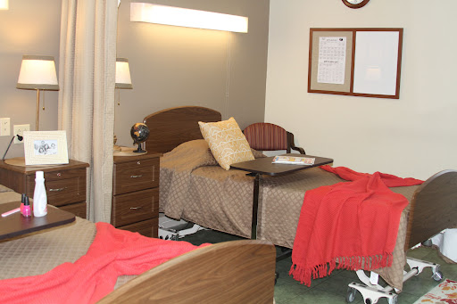 A cozy bedroom setup with two beds, warm blankets, and a bedside table.