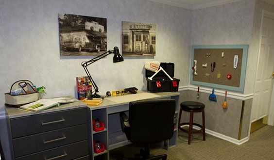 A tidy office workspace with a desk, chair, and wall art.