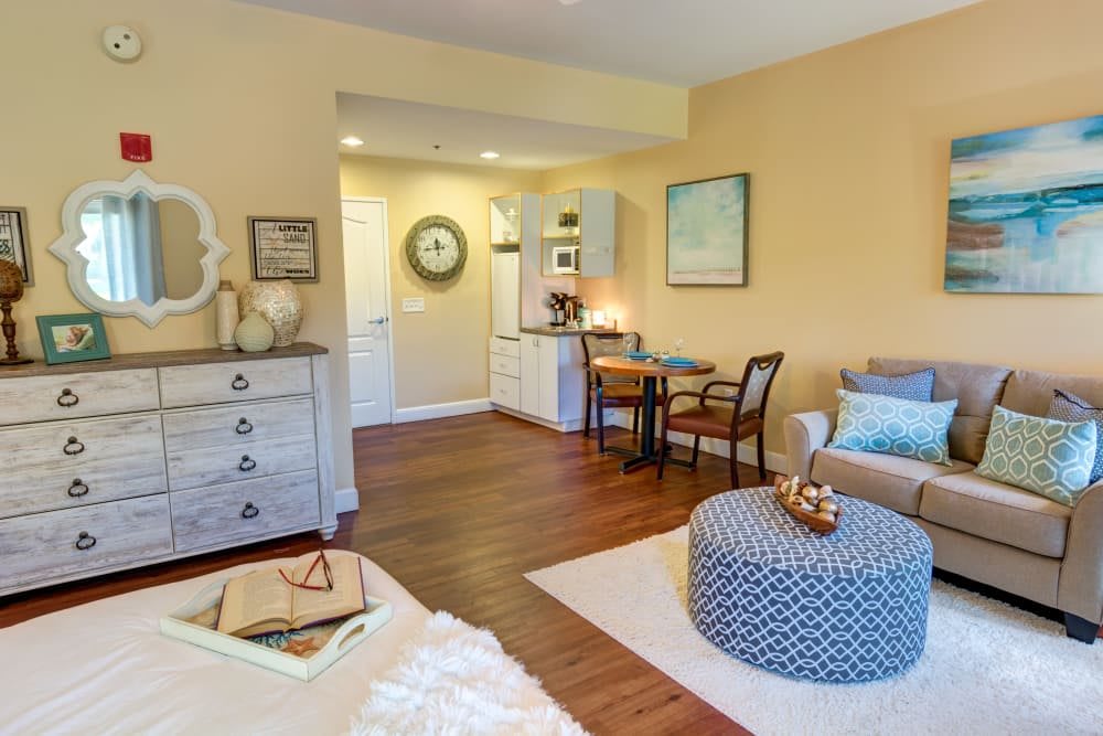 A cozy and modern living room with wood flooring, featuring a small dining area, stylish furniture, and tasteful decor.