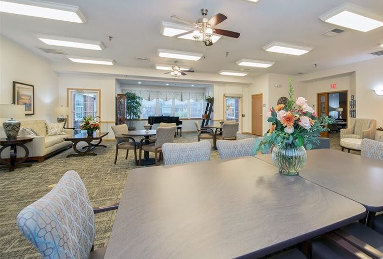 A well-lit interior space with tables, chairs, and floral decorations.
